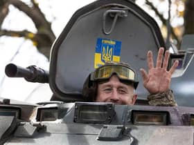 A soldier waves from an armored personnel carrier earlier this month as several villages were liberated in the Kherson district.