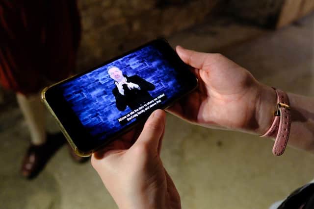 A visitor using The Real Mary King's Close BSL Guide on a tour