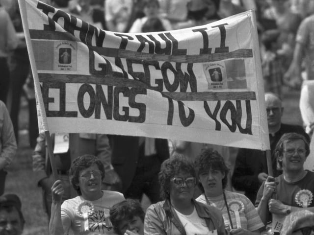 Welcoming banners as the crowd wait to see Pope John Paul II at Bellahouston Park, in Glasgow. The National Mass for Scotland attracted nearly 300,000 people who sung 'Will Ye No Come Back Again?'.
