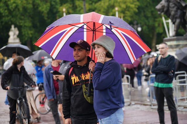 Members of the public gather outside Buckingham Palace in central London.