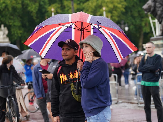 Members of the public gather outside Buckingham Palace in central London.