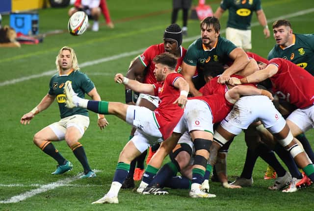 South Africa's scrum-half Faf de Klerk watches as Lions opposite number Ali Price clears the ball.