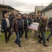 Men carry the coffin of eight-year-old Uliana Troichuk, killed during the Russian attack on a residential building in the village of Apolyanka, outside Uman, Ukraine.