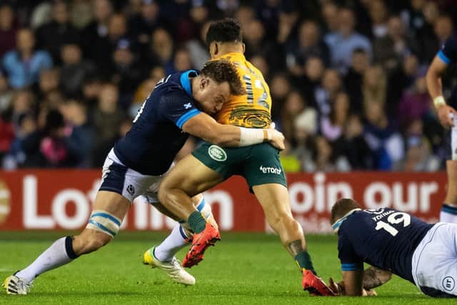 Jack Dempsey tackles Hunter Paisami during his debut for Scotland against Australia, the country he used to represent.  (Photo by Ross Parker / SNS Group)