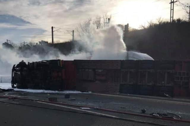 Dramatic images from the scene show the articulated lorry, which was carrying a cargo of pigs, lying on its side across both lanes of the carriageway.