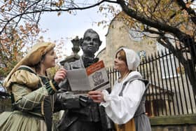 A statue of Robert Fergusson stands outside the Canongate Kirk