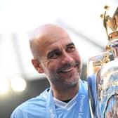 Manchester City manager Pep Guardiola poses for a photo with the Premier League trophy. (Photo by Michael Regan/Getty Images)