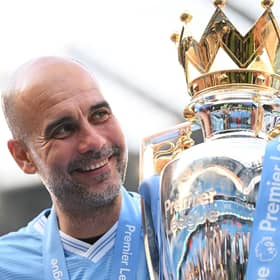 Manchester City manager Pep Guardiola poses for a photo with the Premier League trophy. (Photo by Michael Regan/Getty Images)