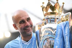 Manchester City manager Pep Guardiola poses for a photo with the Premier League trophy. (Photo by Michael Regan/Getty Images)