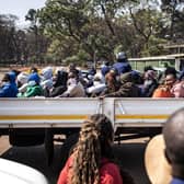 Family members gather around some of the three dozen arrested local election observers as they sit on a flat bed truck ahead of their court hearing at the Harare Magistrates Court. The observers re accused of unlawful tabulation of election voting statistics and results.