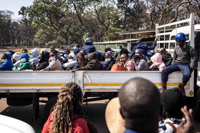 Family members gather around some of the three dozen arrested local election observers as they sit on a flat bed truck ahead of their court hearing at the Harare Magistrates Court. The observers re accused of unlawful tabulation of election voting statistics and results.