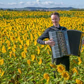 Accordionist Ryan Corbett, from Milngavie, plays in a field of sunflowers at Balgone, East Lothian, for the launch of the classical music Lammermuir Festival which opens on September 7 across East Lothian. Picture date: Wednesday August 30, 2023.