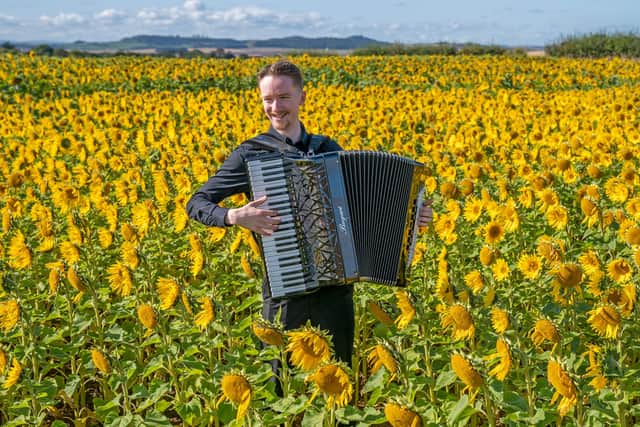 Accordionist Ryan Corbett, from Milngavie, plays in a field of sunflowers at Balgone, East Lothian, for the launch of the classical music Lammermuir Festival which opens on September 7 across East Lothian. Picture date: Wednesday August 30, 2023.