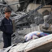A Palestinian boy stands amidst the rubble of a building following Israeli strikes in Rafah in the southern Gaza Strip on November 22, 2023, amid ongoing battles between Israel and the Palestinian militant group Hamas. (Photo by SAID KHATIB / AFP) (Photo by SAID KHATIB/AFP via Getty Images)
