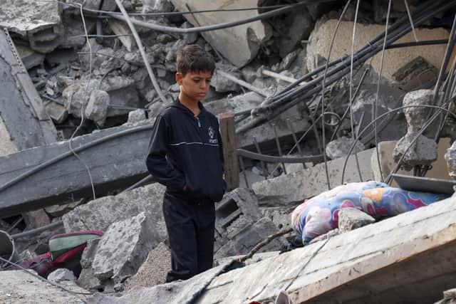A Palestinian boy stands amidst the rubble of a building following Israeli strikes in Rafah in the southern Gaza Strip on November 22, 2023, amid ongoing battles between Israel and the Palestinian militant group Hamas. (Photo by SAID KHATIB / AFP) (Photo by SAID KHATIB/AFP via Getty Images)