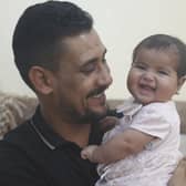 Khalil al-Sawadi plays with his adopted daughter Afraa in Jinderis, Syria