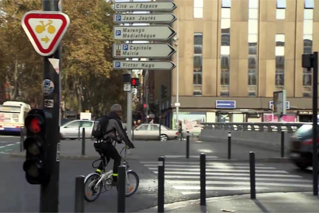 A French sign permitting cyclists to turn right on red after giving way to other traffic and pedestrians. There are similar signs for going straight ahead at some junctions