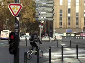 A French sign permitting cyclists to turn right on red after giving way to other traffic and pedestrians. There are similar signs for going straight ahead at some junctions