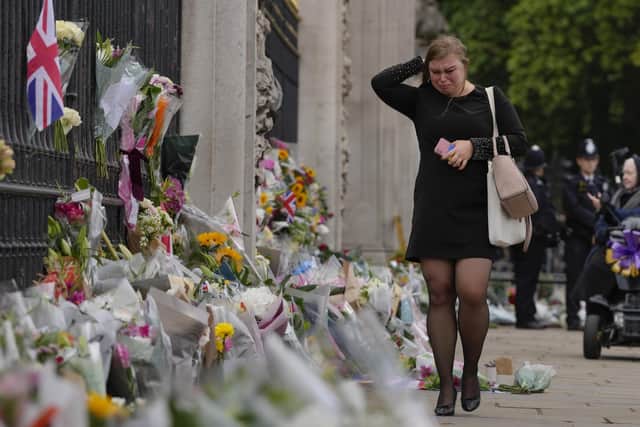 A mourner cries as she pays respect to the Queen outside Buckingham Palace in London. Picture: AP Photo/Kirsty Wigglesworth