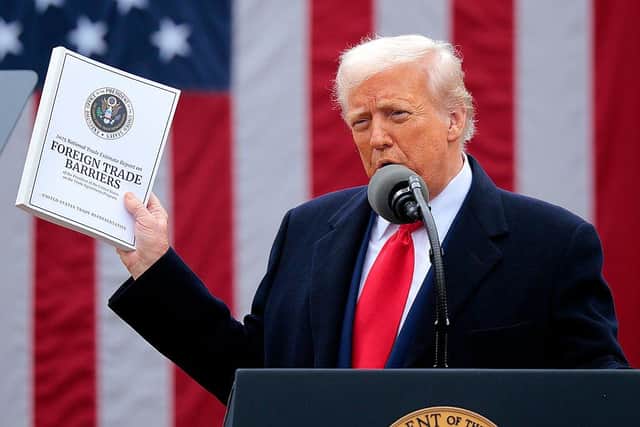 President Donald Trump holds up a copy of a 2025 National Trade Estimate Report as he speaks during a 'Make America Wealthy Again' trade announcement event in the Rose Garden. Picture: Chip Somodevilla/Getty Images