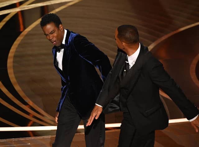Actor Will Smith (R) slaps US actor Chris Rock onstage during the 94th Oscars at the Dolby Theatre in Hollywood, California