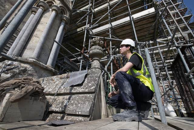 A stonemason on the roof of Salisbury Cathedral during an ongoing restoration project (Photo by Matt Cardy/Getty Images)