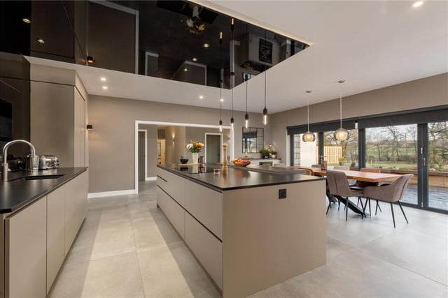 The kitchen is fitted with a range of contemporary kitchen units, central breakfast bar, bi-folding doors to the patio, feature ceiling, and numerous integrated appliances.