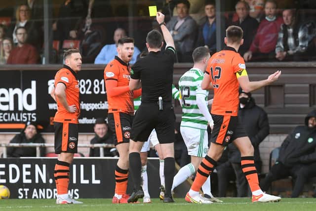Dundee United's Calum Butcher (left) is booked for a tackle on Celtic's David Turnbull (Photo by Craig Foy / SNS Group)