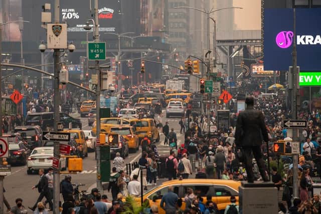 People make their way around Times Square amid smoke from Canada wildfires in New York City. New York topped the list of most polluted major cities in the world this week, as smoke from the fires continues to blanket the East Coast.  (Photo by Eduardo Munoz Alvarez/Getty Images)