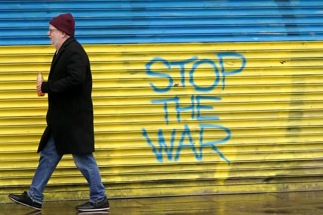 A man walks past anti-war graffiti in support of Ukraine, painted on shutters in Dublin city centre, following Russia's invasion of Ukraine. Picture date: Wednesday March 2, 2022.