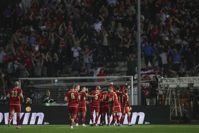 The Aberdeen players celebrate Duk's goal in front of their fans in Thessaloniki.