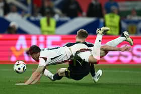 Scotland's Stuart Armstrong falls under the challenge of Hungary defender Willi Orban but no penalty was awarded. (Photo by FABRICE COFFRINI/AFP via Getty Images)