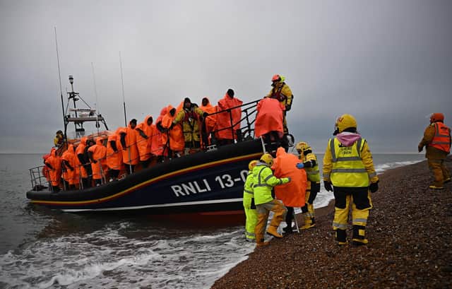 A group of people picked up at sea attempting to cross the English Channel are helped ashore from an RNLI lifeboat at Dungeness (Picture: Ben Stansall/AFP via Getty Images)