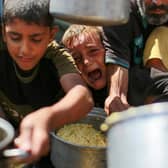 Children struggle to to get rice from a charity kitchen providing food for free in the west of Gaza City (Picture: Bashar Taleb/AFP via Getty Images)