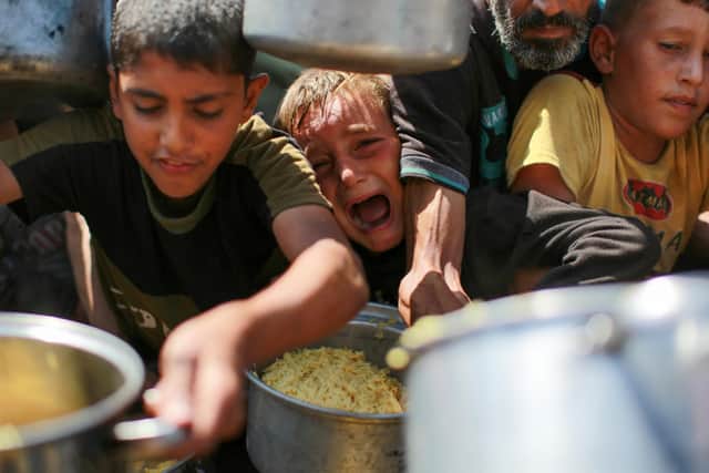 Children struggle to to get rice from a charity kitchen providing food for free in the west of Gaza City (Picture: Bashar Taleb/AFP via Getty Images)