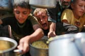 Children struggle to to get rice from a charity kitchen providing food for free in the west of Gaza City (Picture: Bashar Taleb/AFP via Getty Images)