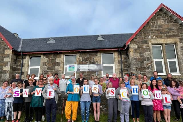 Parents and residents living on Luing standing outside the currently mothballed primary school calling for it to be saved from permanent closure (pic: Luing SOS Campaign)