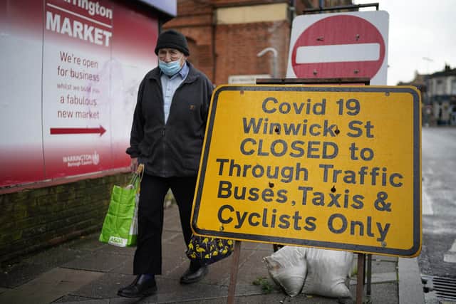 People wear face masks in Warrington town centre as the borough enters Covid-19 Tier 3 'Very High' lockdown restrictions. Picture: Christopher Furlong/Getty Images