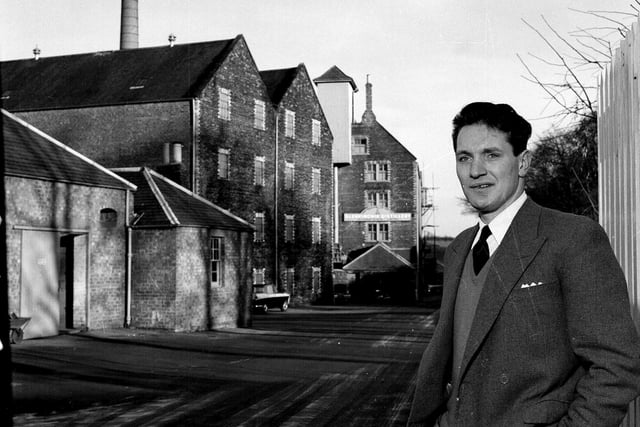 Mr W S Robertson, the manager of the Glenkinchie Whisky Distillery in East Lothian, stands in front of the distillery in December 1962.