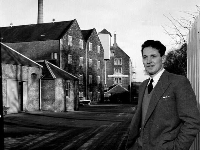 Mr W S Robertson, the manager of the Glenkinchie Whisky Distillery in East Lothian, stands in front of the distillery in December 1962.