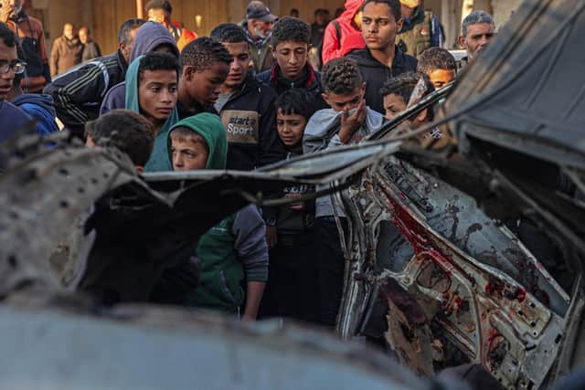 Onlookers gather around a car that was destroyed in an Israeli raid in Rafah in the southern Gaza Strip, amid ongoing battles between Israel and the armed Hamas movement. Picture: Said Khatib/AFP via Getty Images