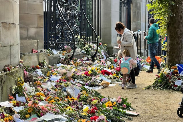 A family reads the messages of bereavement left.