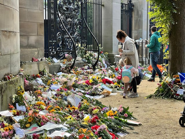 A family reads the messages of bereavement left.