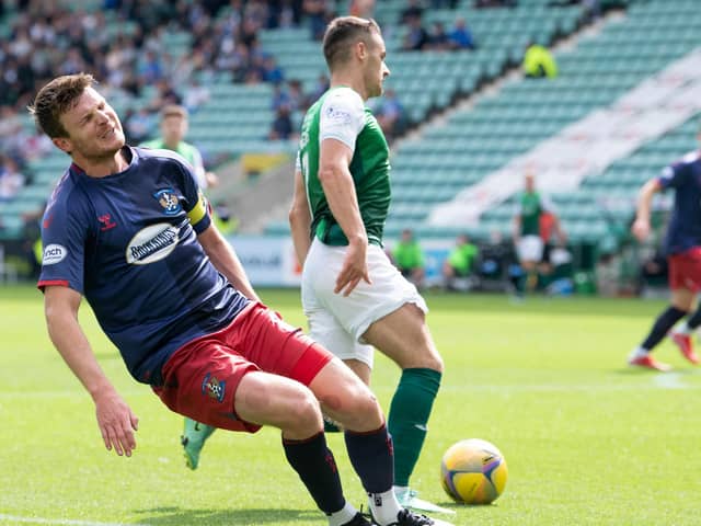 Kilmarnock captain Chris Stokes clutches his hamstring with Kyle Magennis set to strike. Referee Bobby Madden stopped play   (Photo by Ross Parker / SNS Group)