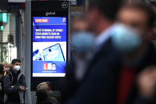 A digital advertising board in Glasgow displaying a news article about the vaccine breakthrough