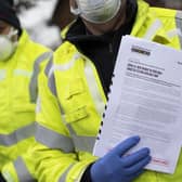 Volunteers from various emergency services and council members go door-to-door to distribute Covid-19 tests to residents homes. Picture: Dan Kitwood/Getty Images