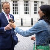 Health Secretary Matt Hancock, looks at the phone of his aide Gina Coladangelo as they leave the BBC in central London on June 6, 2021.