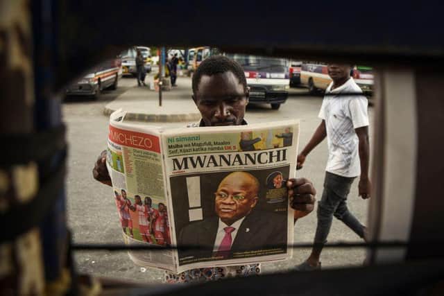 A man reads a newspaper with a headline announcing the death of Tanzania's President John Magufuli (Photo: -/AFP via Getty Images)