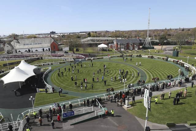 Jockeys, owners, and trainers stand in the parade ring, before the first race on the third day of the Grand National Horse Racing meeting at Aintree Racecourse in 2021. Photo: AP Photo/Scott Heppell, Pool, File.