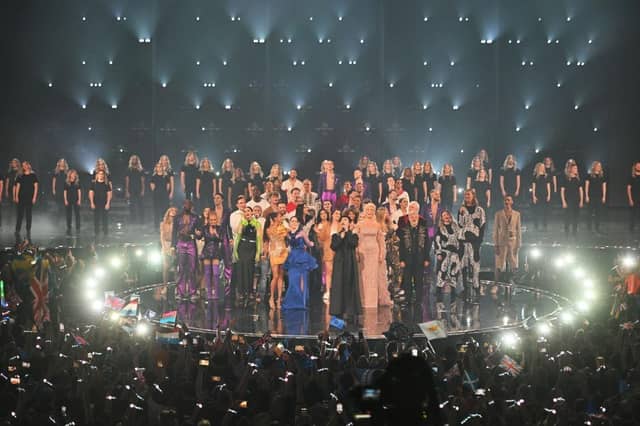 Duncan Laurence performs "You'll Never Walk Alone" on stage during The Eurovision Song Contest. Groups of singers from Ukraine joined in via video link, while all entrants in the competition also joined him on stage.